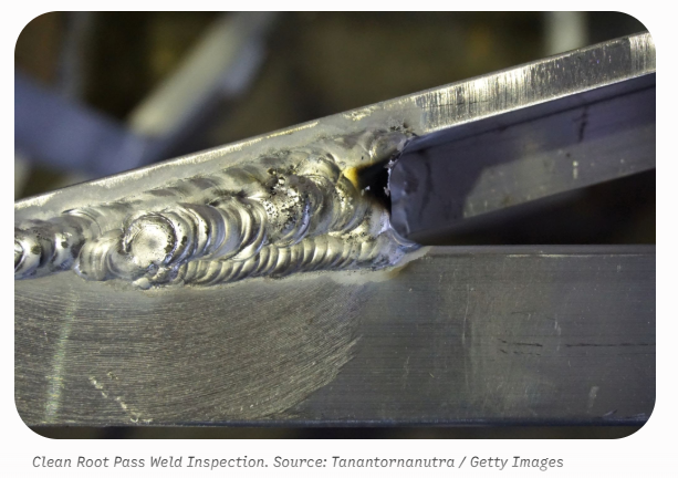 A close-up view of a metal joint featuring a freshly cleaned, uniform weld bead running smoothly along the seam between two thick steel plates.